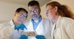 Three scientists looking at a glowing i-pad