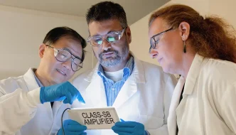 Three scientists looking at a glowing i-pad